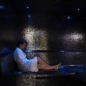 alt="Female Guest Relaxing in Sauna"