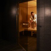alt="Male Guest resting in the Sauna Room"